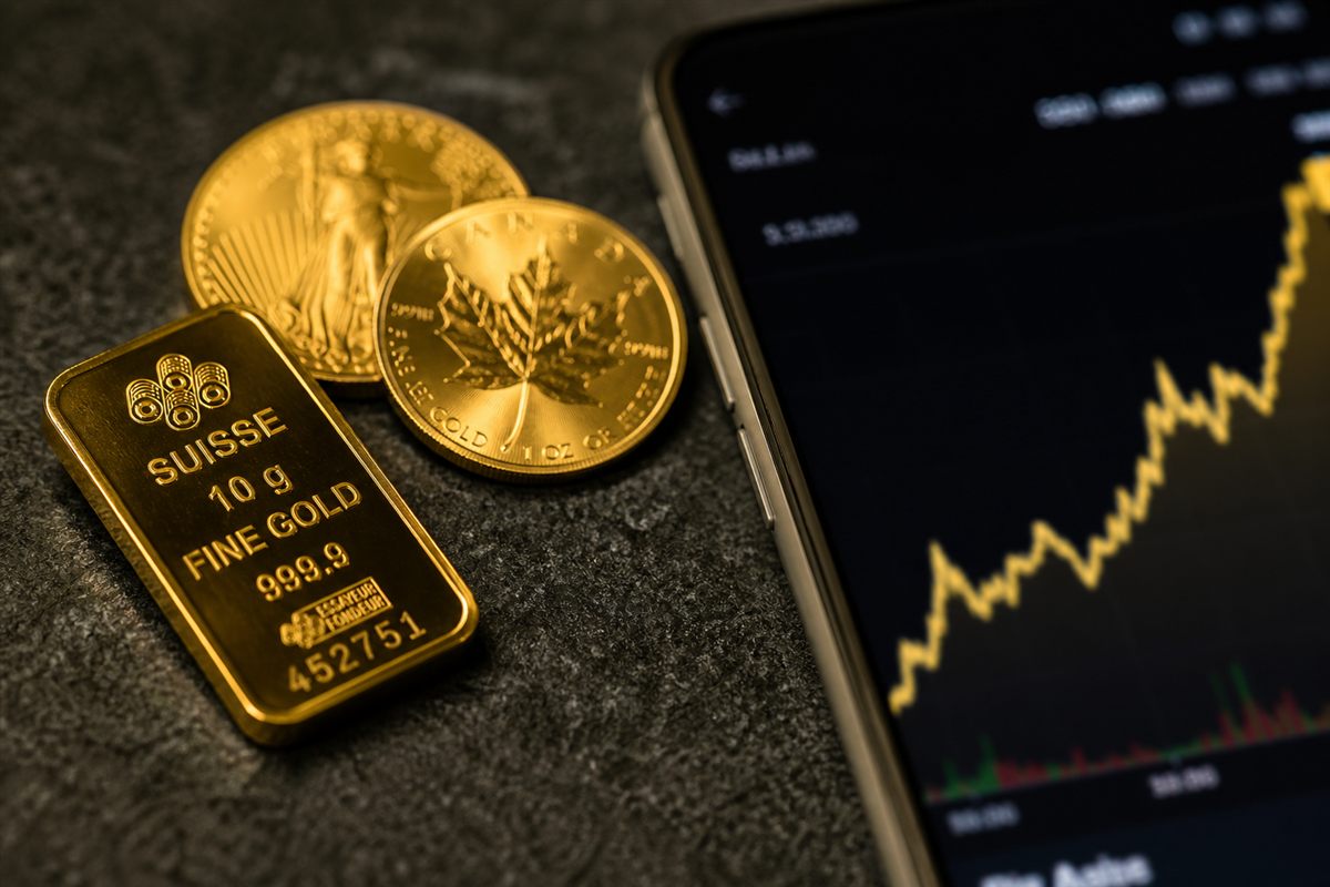 Lingot d'or et pièces devant un cours en hausse