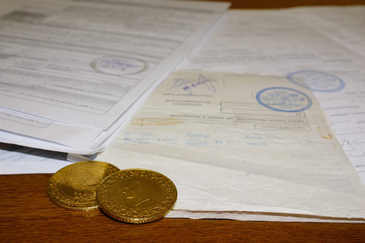 Bordereau d'achat et pièces d'or sur un bureau